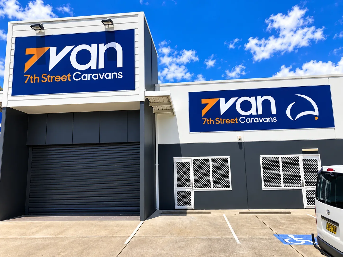 7th Street Caravans showroom in Heatherbrae with two large navy signs reading 7van and 7th Street Caravans