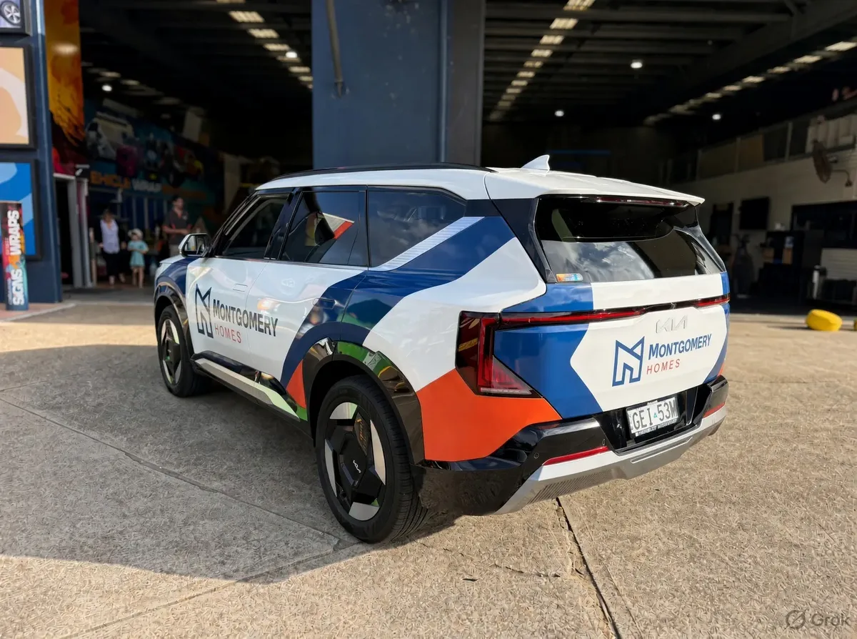 Montgomery Homes branded vehicle in the new white, navy and orange livery, rear view at the signage workshop entrance