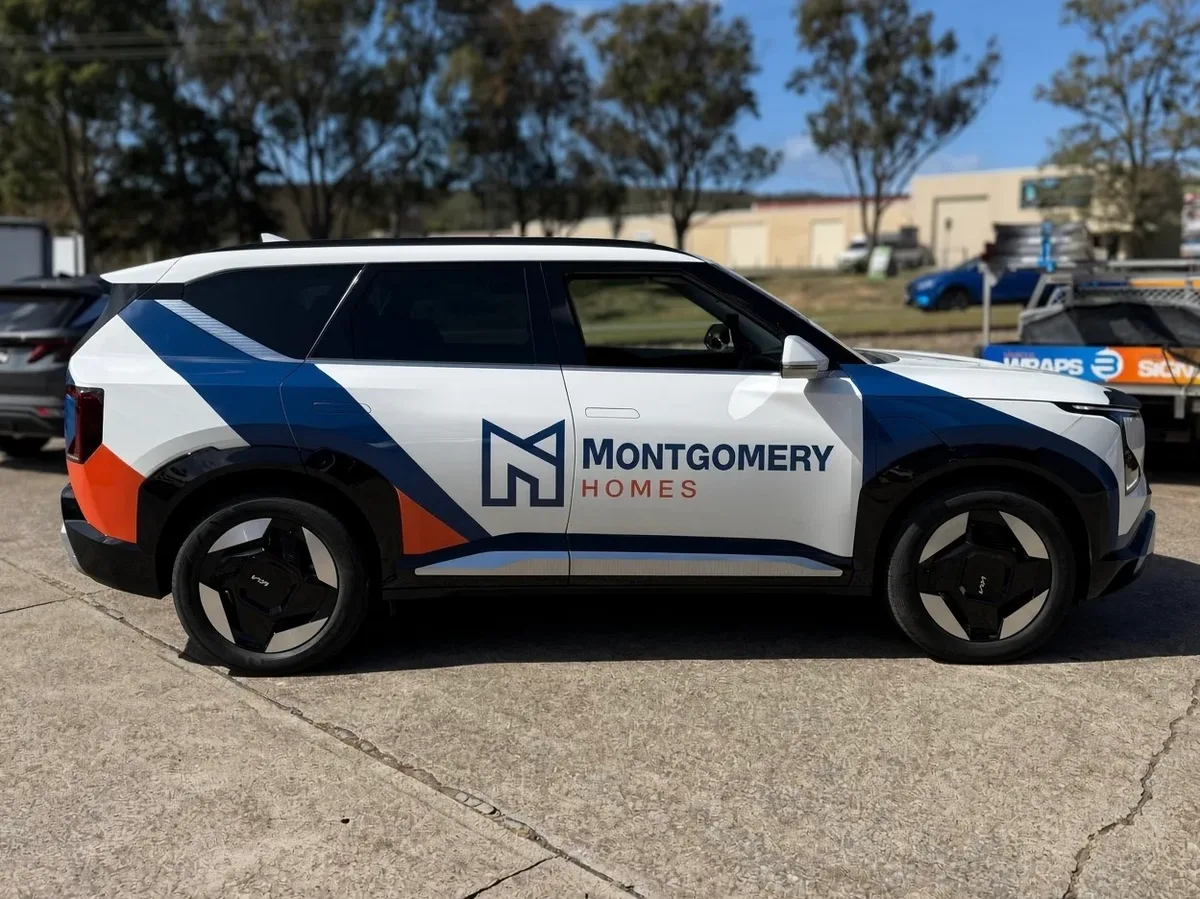 Montgomery Homes branded vehicle in the new white, navy and orange livery, parked outdoors