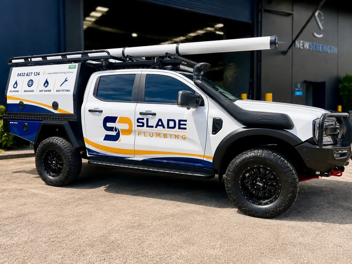 Slade Plumbing dual-cab Ford Ranger ute in white with navy and gold graphics and a matching service canopy