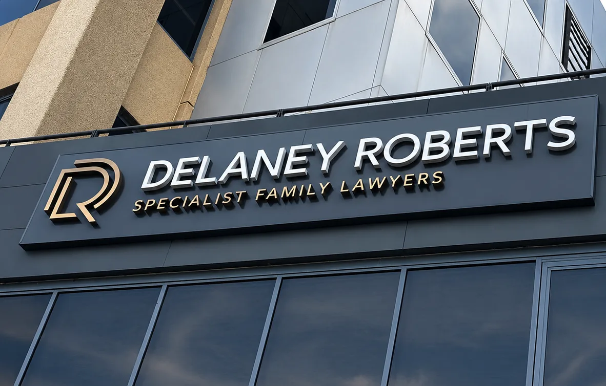Delaney Roberts Specialist Family Lawyers shopfront sign, illuminated 3D lettering in silver and gold on a dark facade