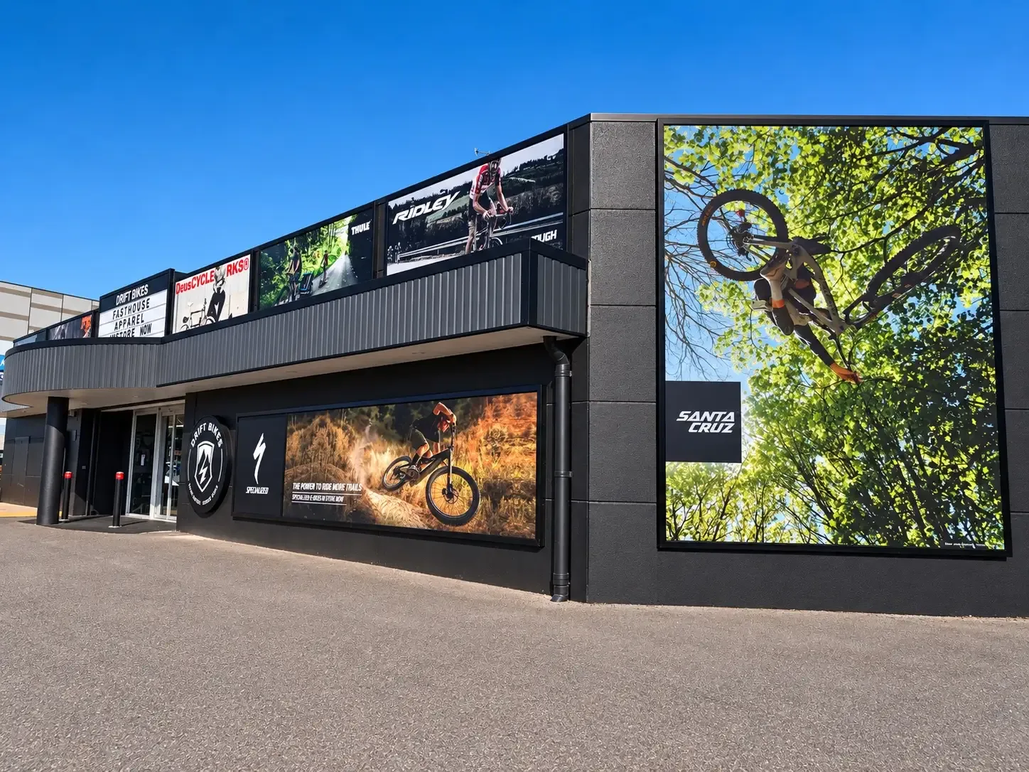 Drift Bikes shopfront in Kotara with large cycling brand graphics and a Santa Cruz mountain bike mural