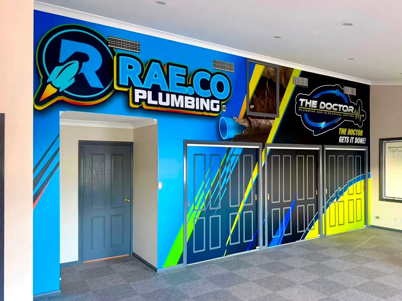 RAE.CO Plumbing and The Doctor logos as a wall graphic in their Gateshead premises.