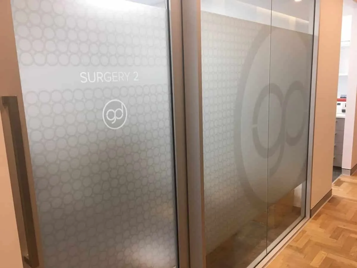 Frosted film with a circle pattern, SURGERY 2 lettering and The Good Dentist logo on internal glass walls