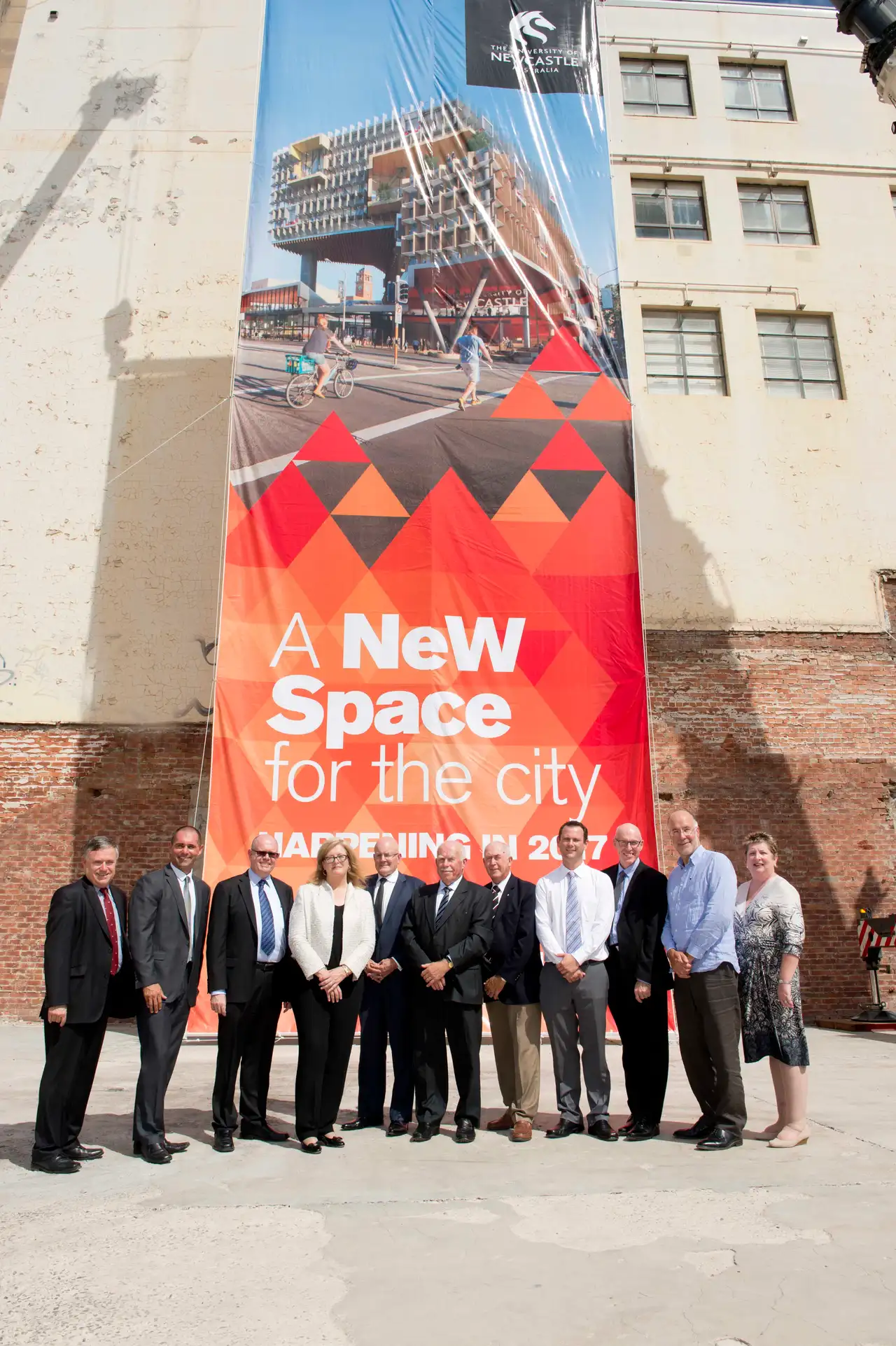 Group of people in front of a large printed event banner produced by Big Colour