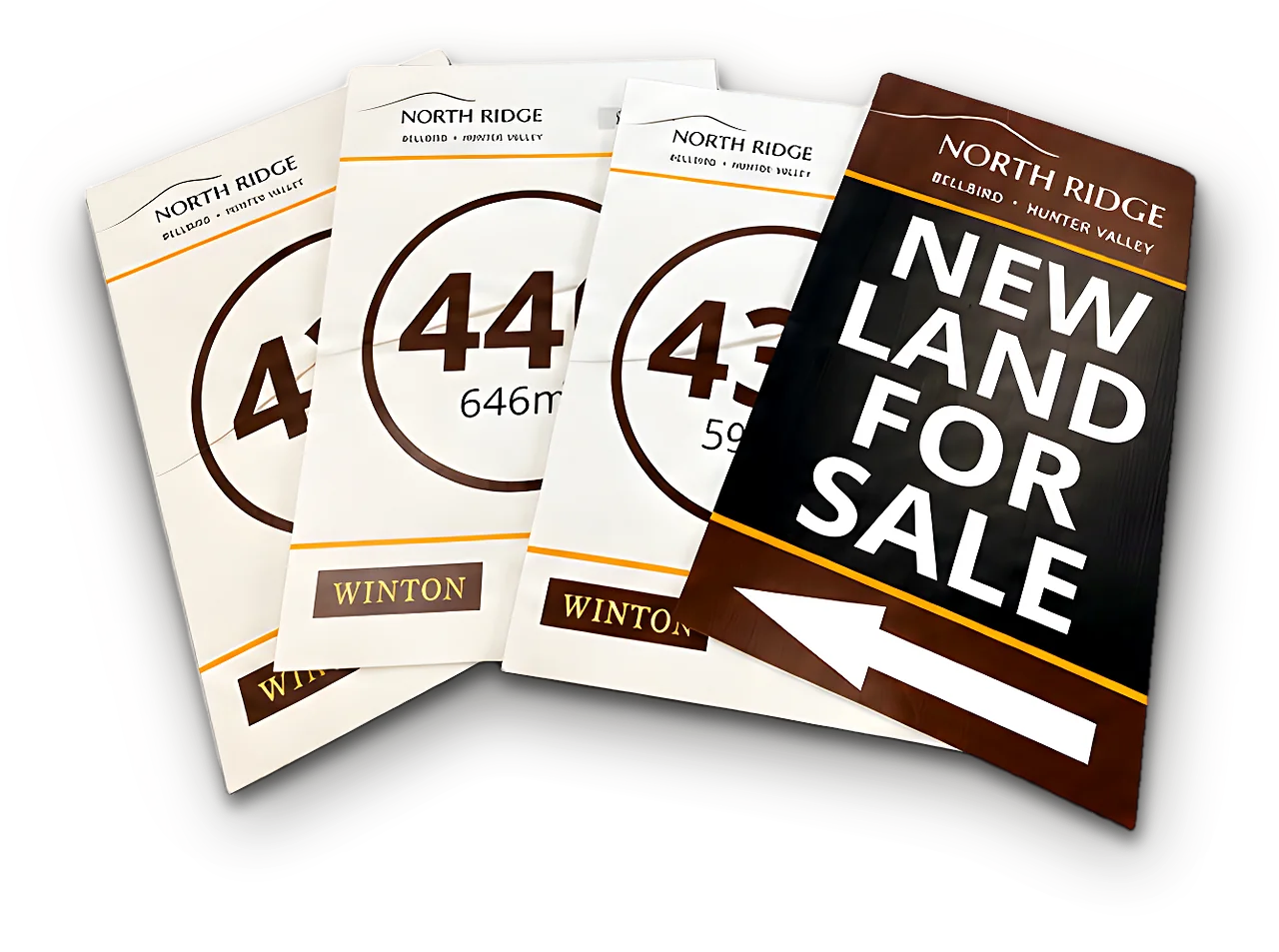 Four North Ridge corflute lot signs fanned out, with a brown New Land For Sale arrow board in front