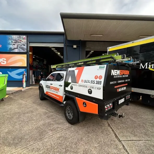 NewSpark ute parked at the Big Colour workshop, black canopy and orange lower panel from the rear quarter