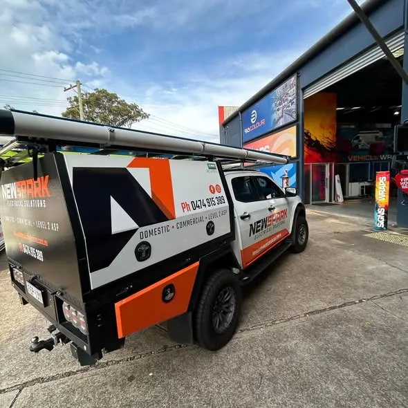 NewSpark Electrical Solutions ute out the front of the Big Colour signage, ladder rack and awning fitted