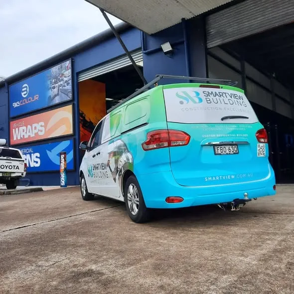 Rear three-quarter of the Smartview Building van, gradient panels and the SB Construction Excellence logo