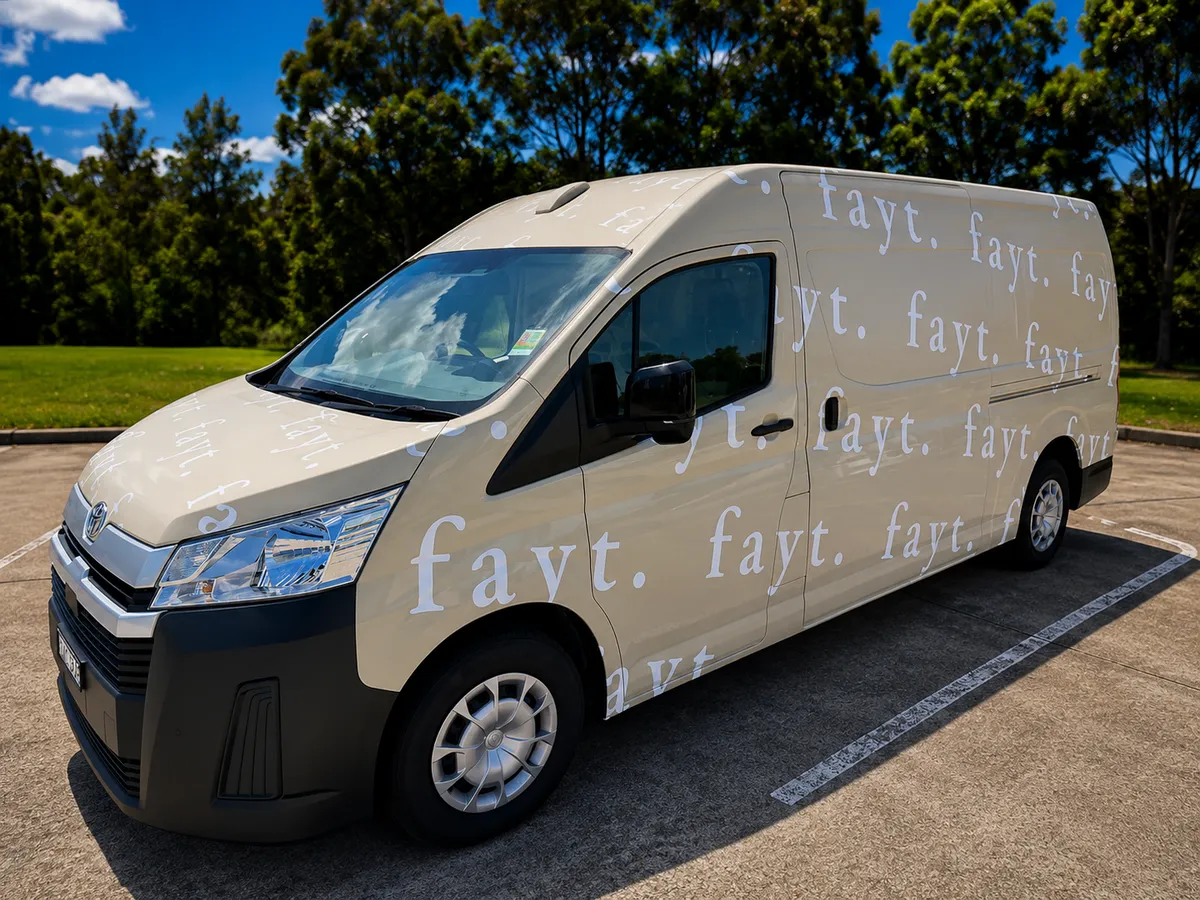 Fayt cream van wrapped in the repeating fayt. lettering