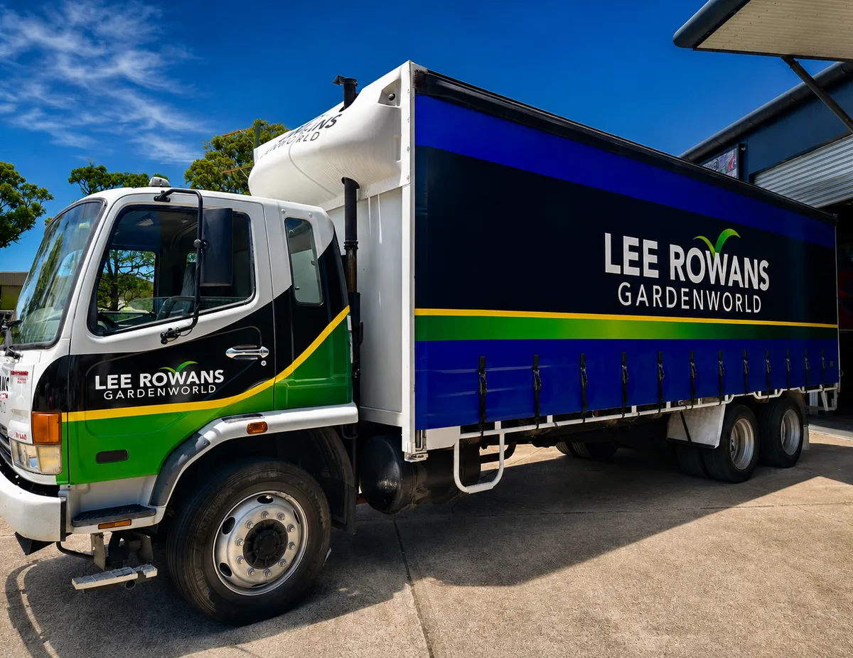 Lee Rowans Gardenworld curtain-sider truck in black, green and blue fleet livery outside the Big Colour workshop