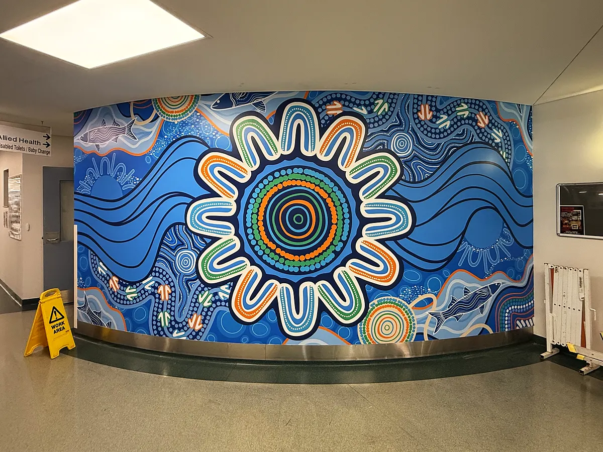 Aboriginal-inspired mural with concentric circles in a facility corridor