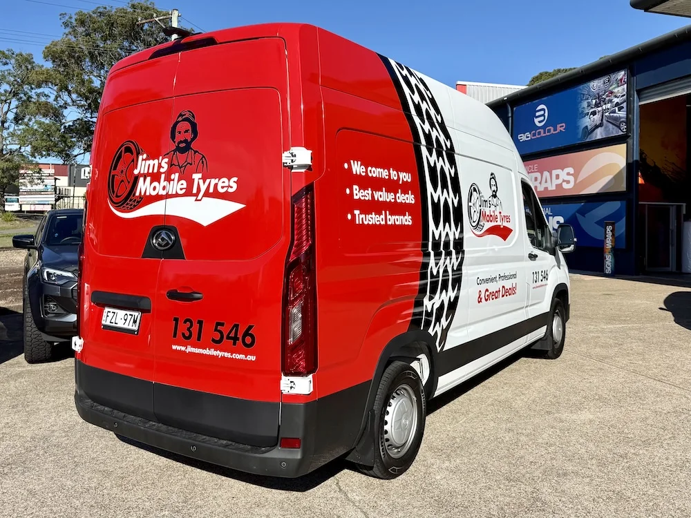 Jim's Mobile Tyres van in a red, white and black wrap with tyre tread graphics